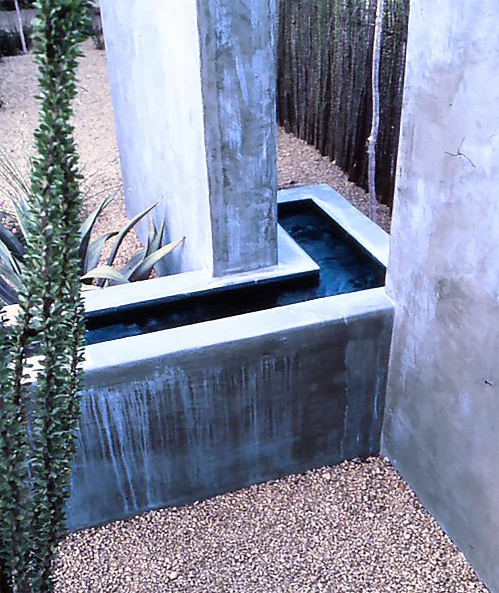 The hidden water source returns behind the offset flanking walls.