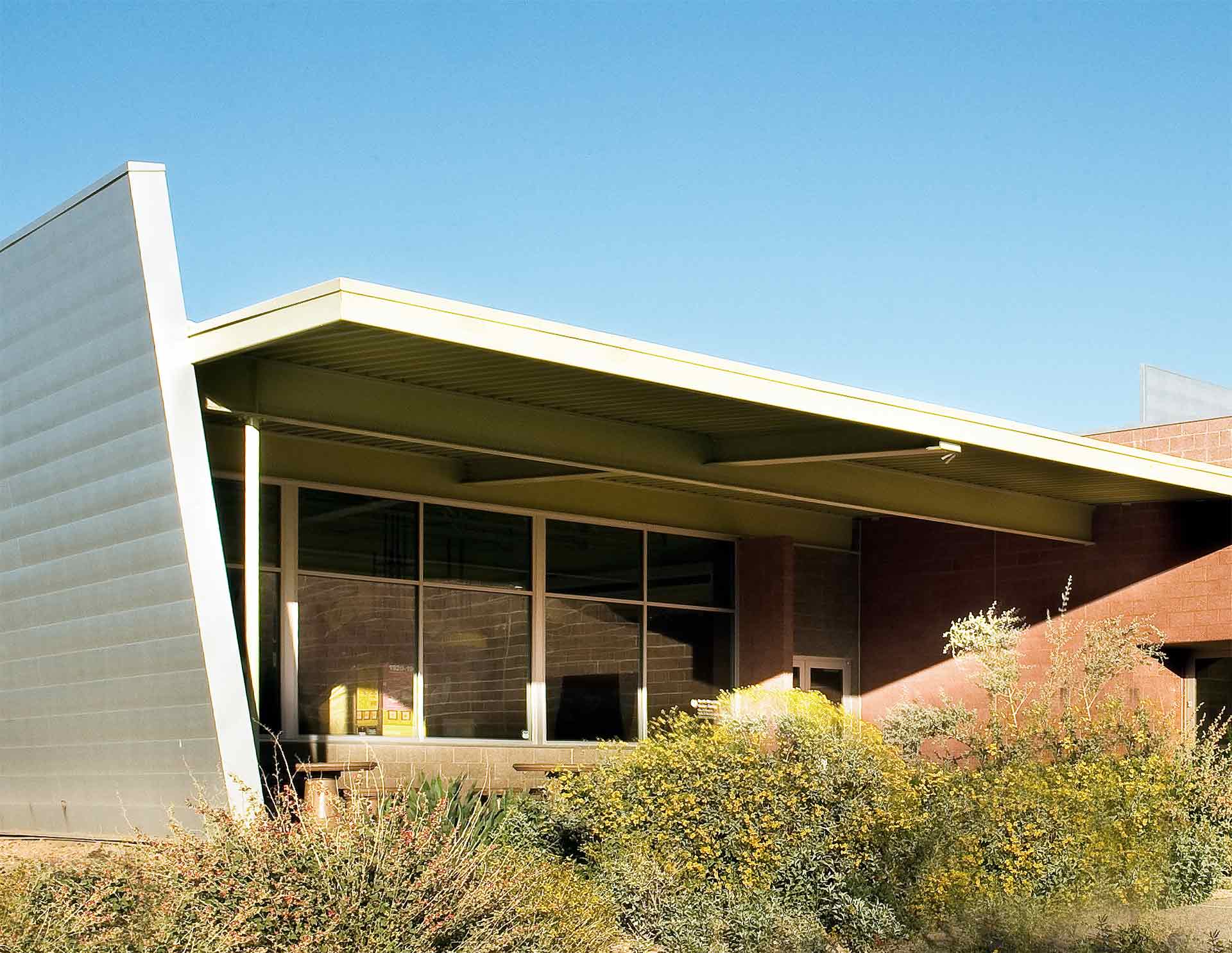 Zinc-clad wall angled to reference the angle of the natural geolocal feature that backdrops the site.