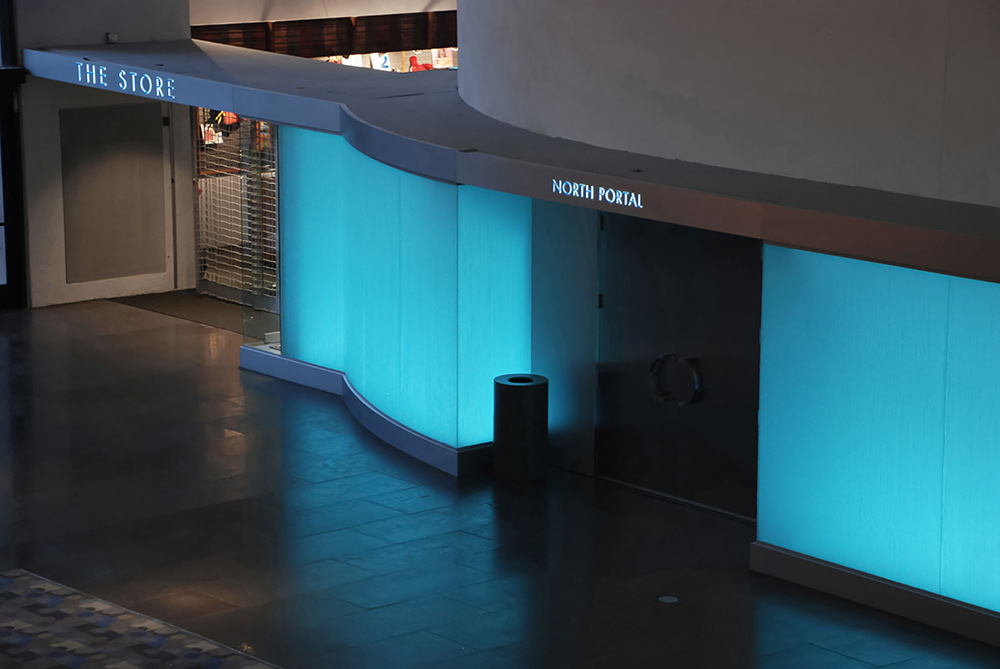 Illuminated art glass wall flanking the portals into the theater.