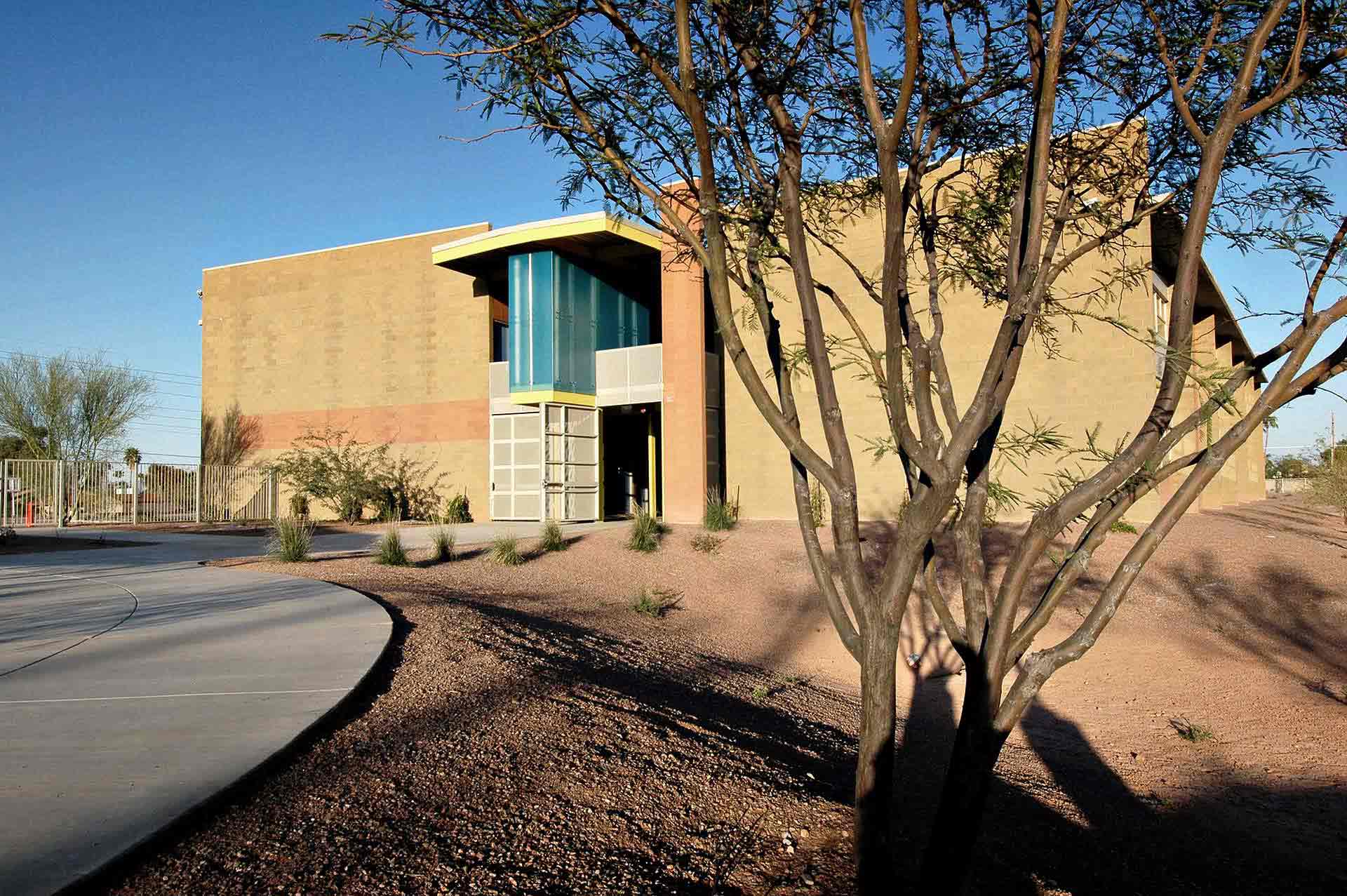 The west face of the classroom building showing the blue resin entry feature.